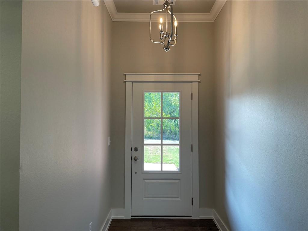 Image 3: Entryway with crown molding, a chandelier, and woo
