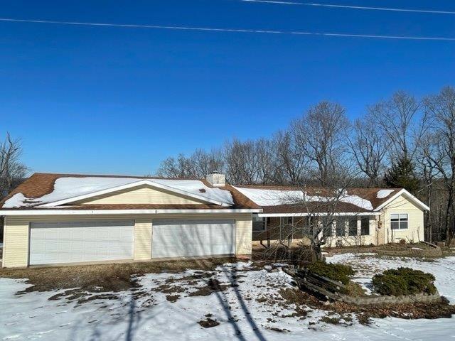 Image 1: View of snowy exterior with a garage