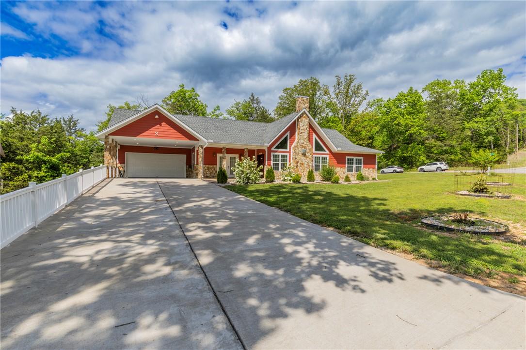 Image 2: Red-sided residence featuring stone accents and a