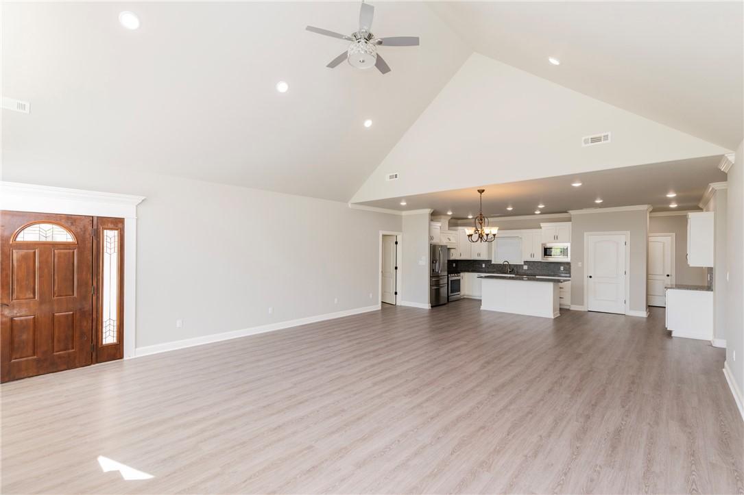 Image 4: Open-concept living area featuring vaulted ceiling