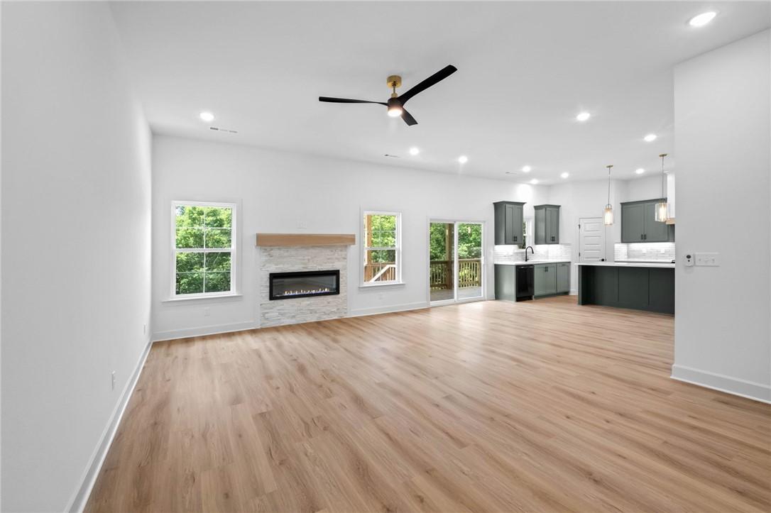 Image 3: Spacious open-concept room featuring wood-finish f