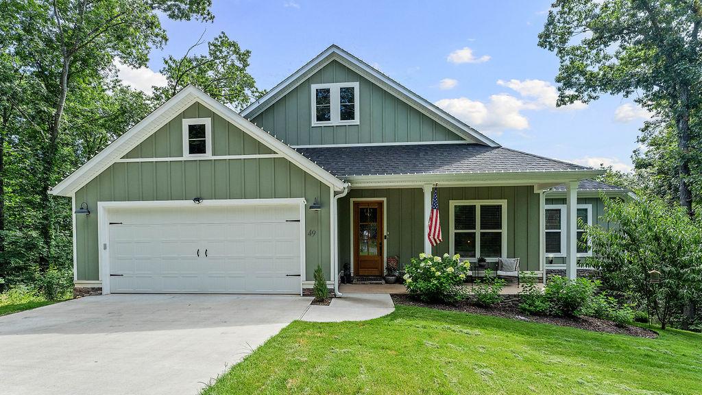 Image 1: Craftsman-style exterior with green siding and whi