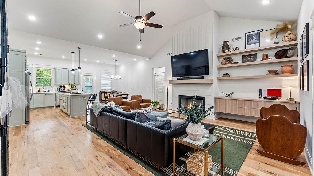Image 2: Open-concept living area featuring light wood-fini