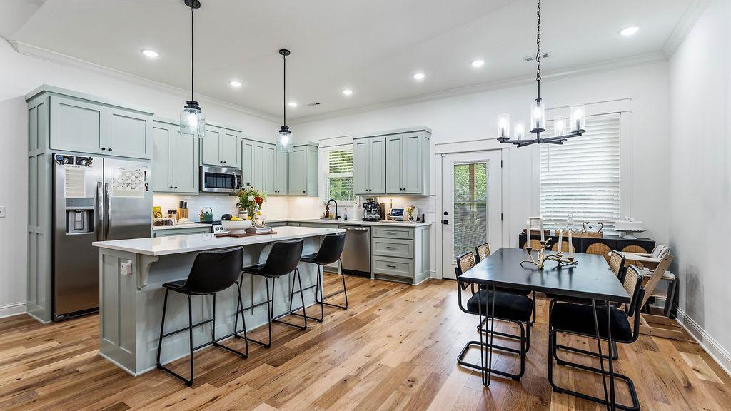 Image 3: Open-concept kitchen and dining area featuring woo