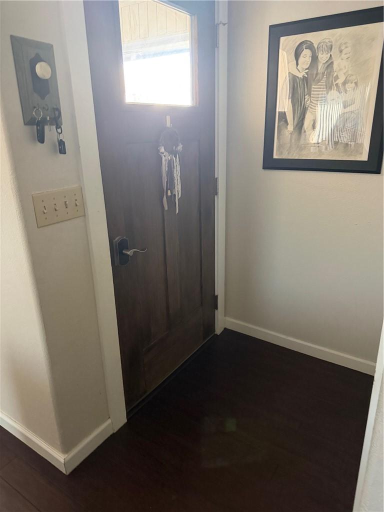 Image 4: Doorway to outside featuring baseboards and wood f
