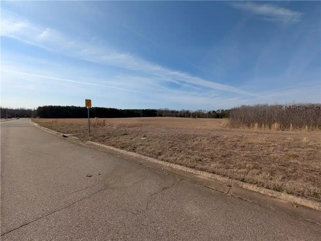 Image 1: View of asphalt street with curbs, a view of rural