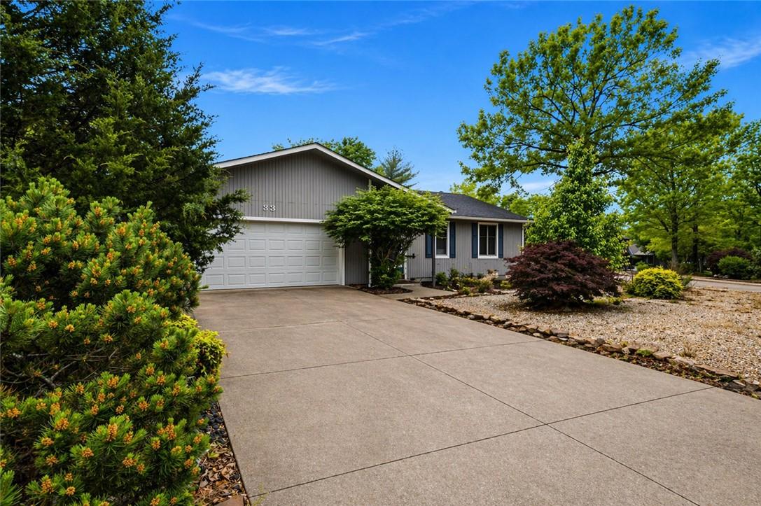 Image 2: Exterior featuring grey siding, a two-car garage,