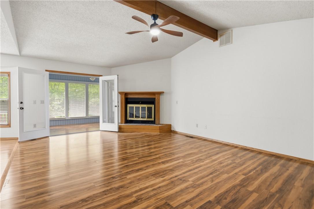 Image 3: Spacious living area featuring wood-finish floorin