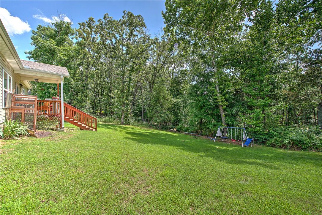 Image 2: Spacious backyard featuring a covered patio with w