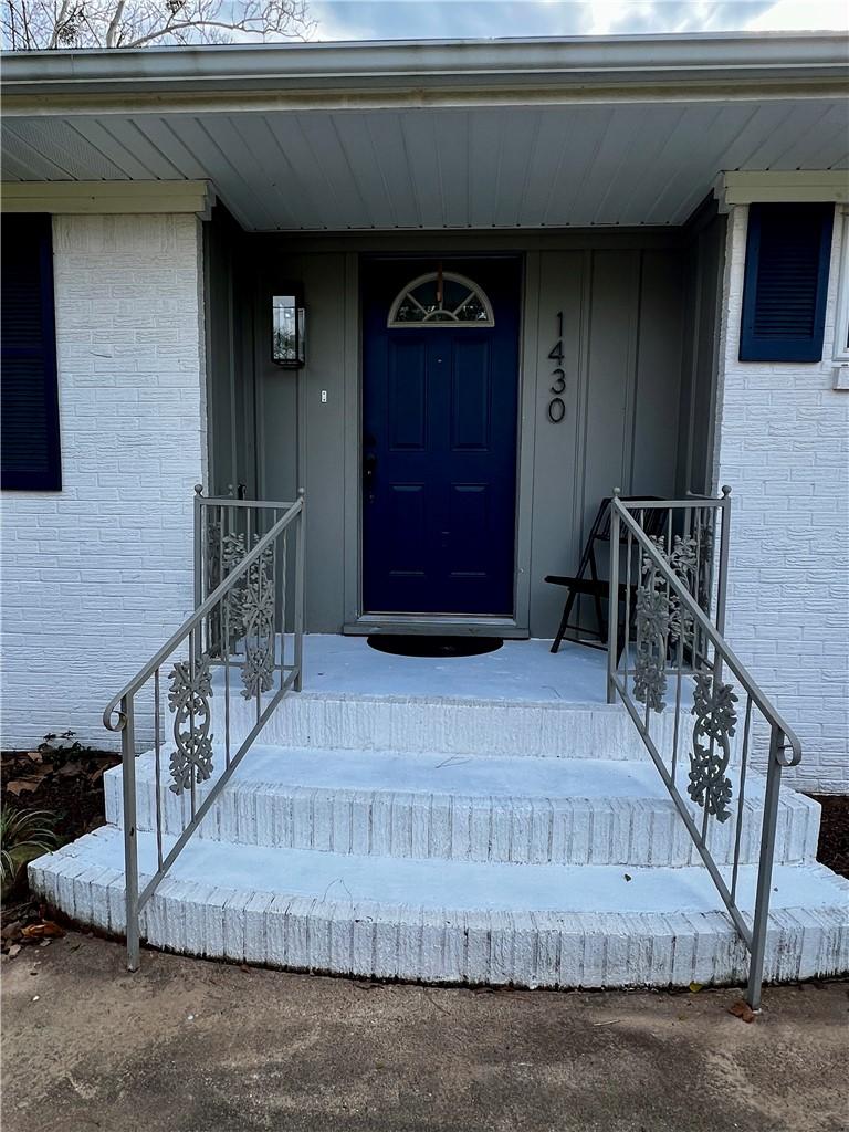 Image 3: Property entrance featuring brick siding and a por