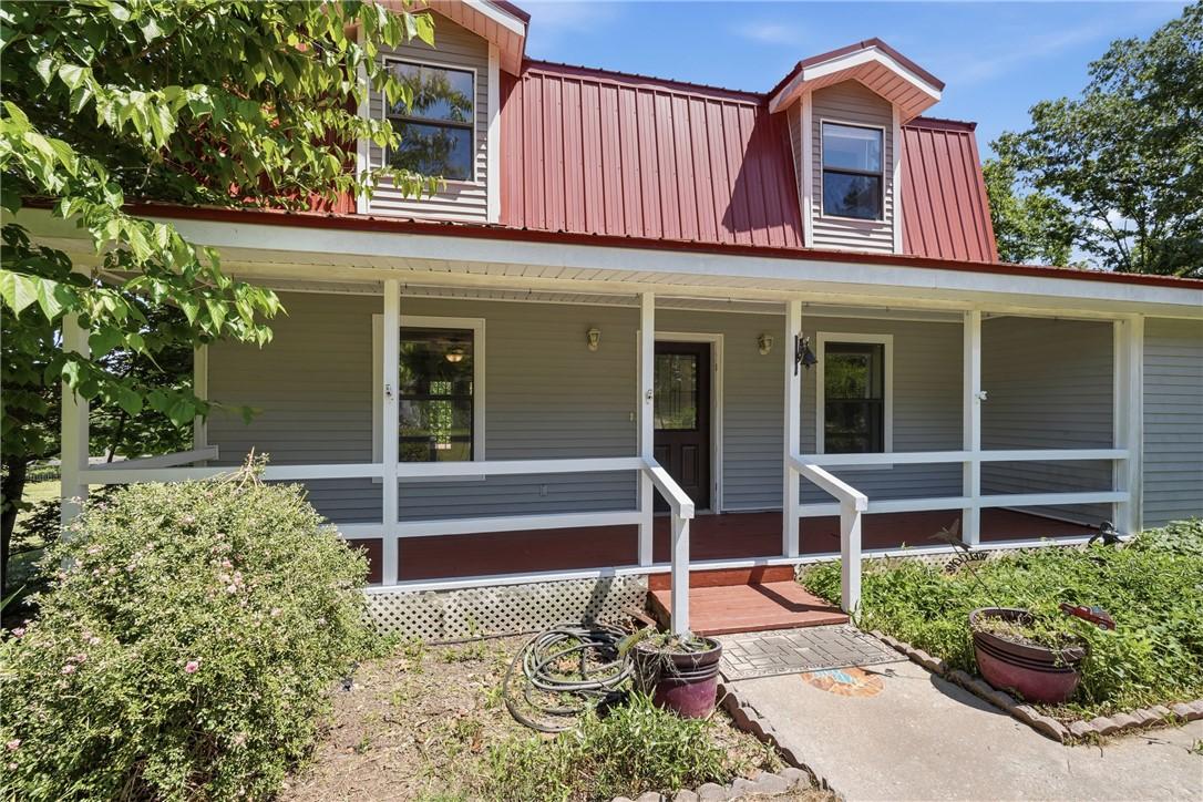 Image 3: Exterior featuring a red metal roof, dormer window