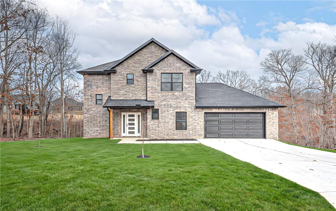 Image 1: View of front of home with an attached garage, dri