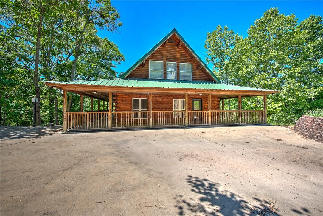 Image 1: Rustic wood cabin exterior with a bright green met