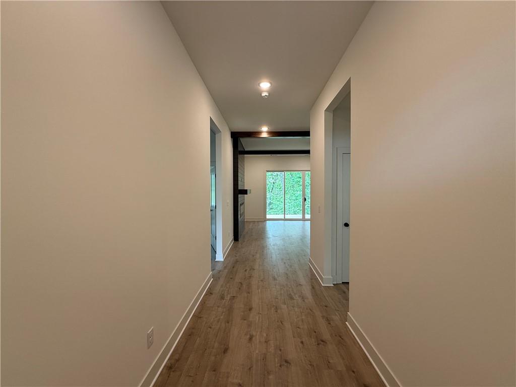 Image 2: Inviting hallway featuring wood-finish flooring, r
