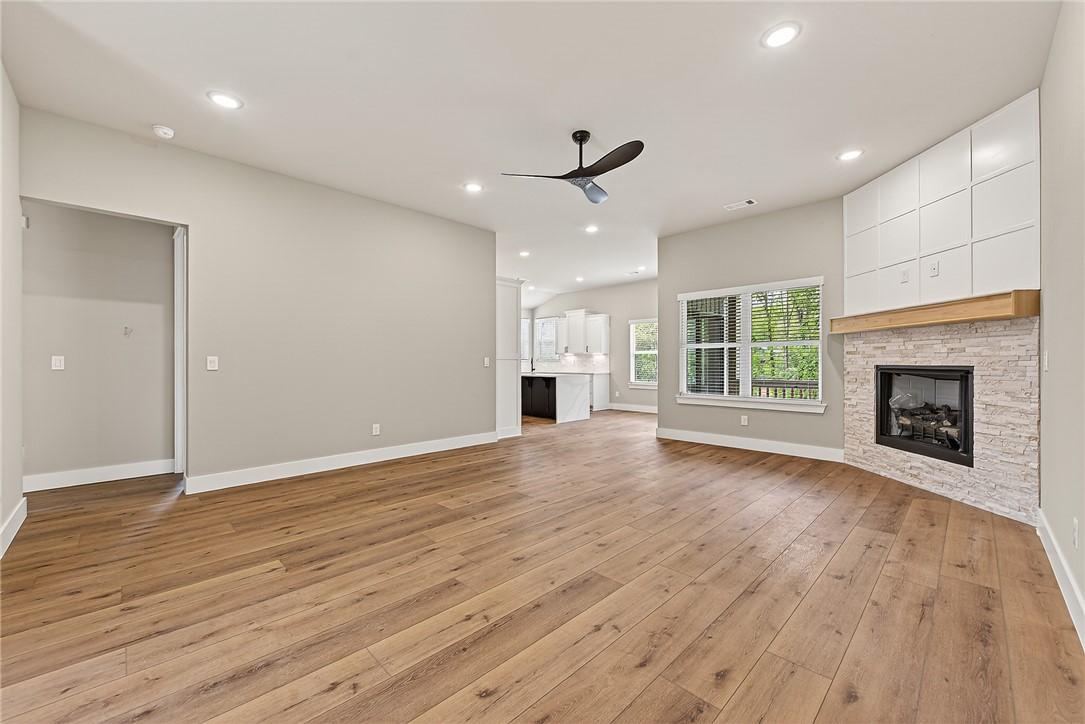 Image 3: Spacious living area featuring wood-finish floorin