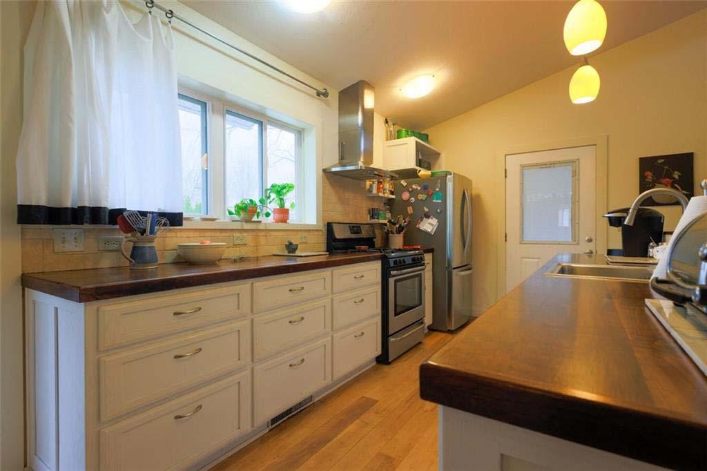 Image 4: Kitchen featuring wood-finish countertops, white c
