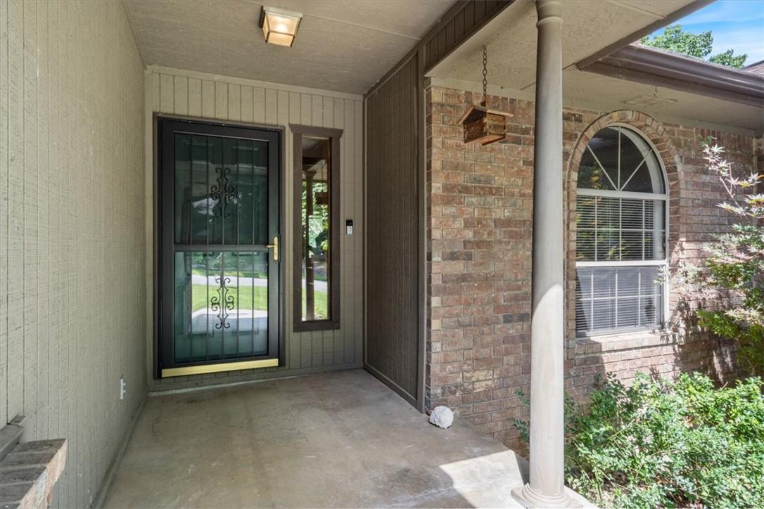 Image 3: Covered entry featuring a brick facade with an arc