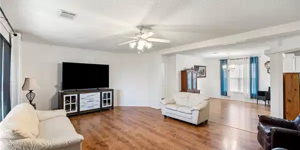 Image 4: Spacious living area featuring wood-finish floorin
