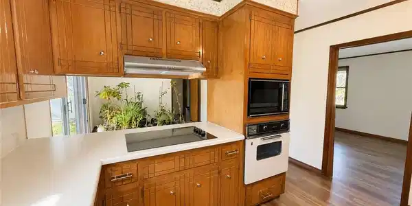 Image 2: Kitchen featuring wood cabinetry, white countertop
