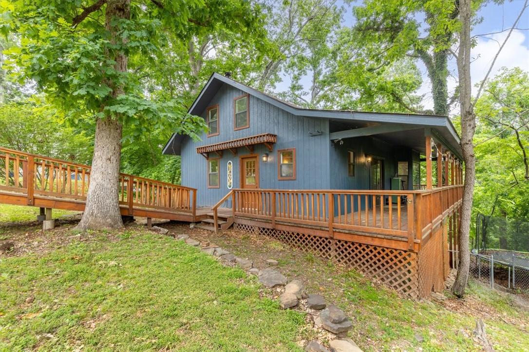 Image 3: Blue siding exterior with a dark roof and a promin