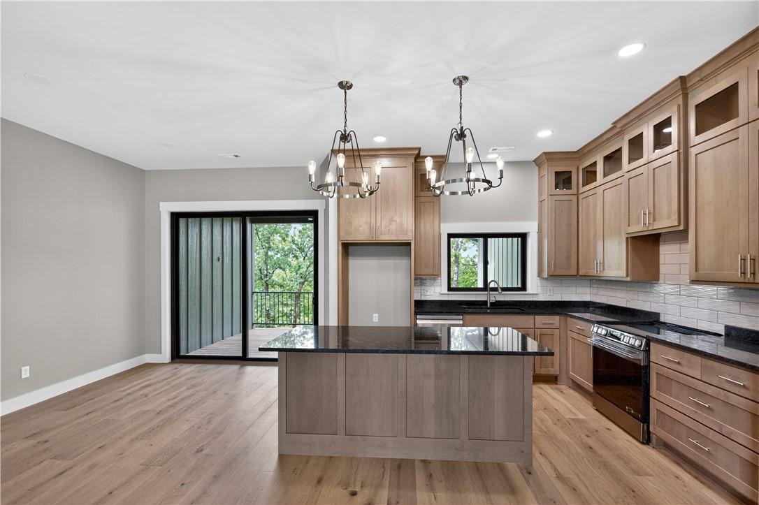 Image 4: Open-concept kitchen featuring custom cabinetry an
