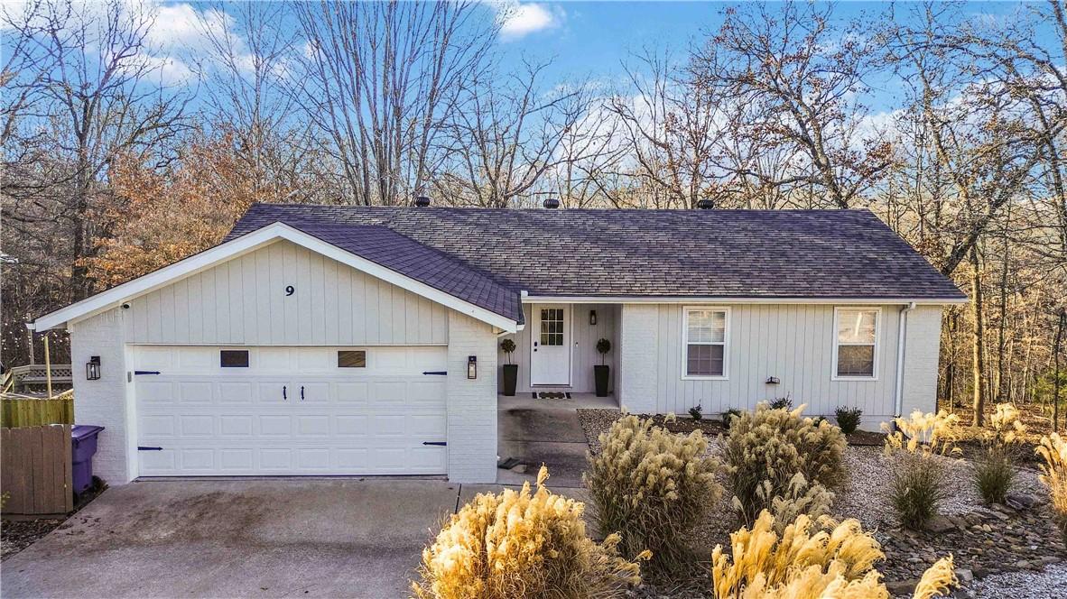 Image 2: Single story home with concrete driveway, covered