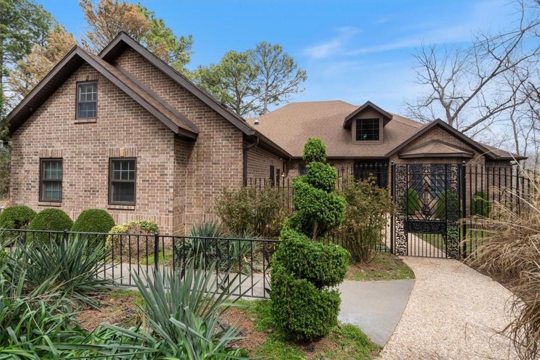 Image 3: View of front of property with a gate, brick sidin