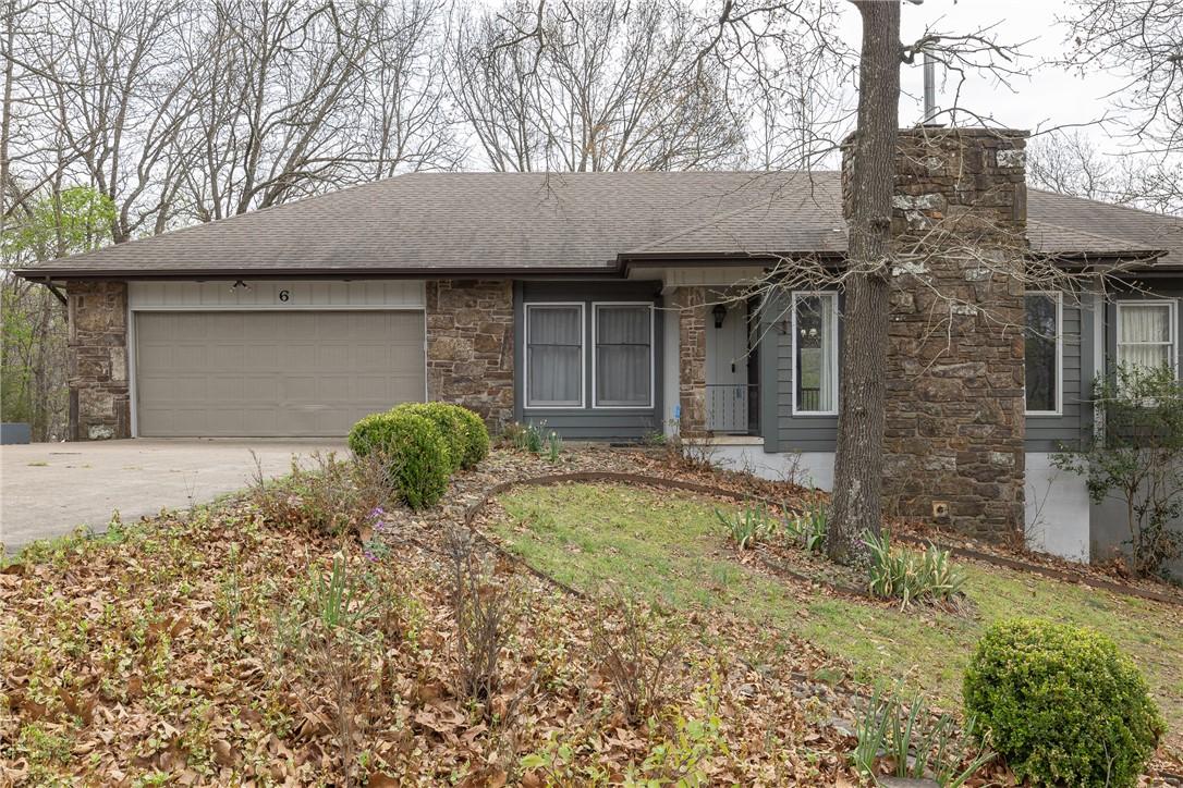Image 1: Ranch-style home featuring stone siding, a garage,