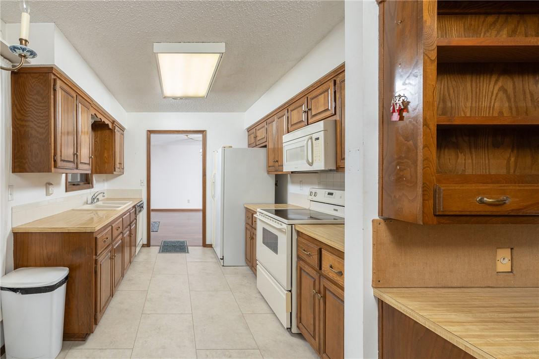 Image 3: Kitchen with light countertops, white appliances,
