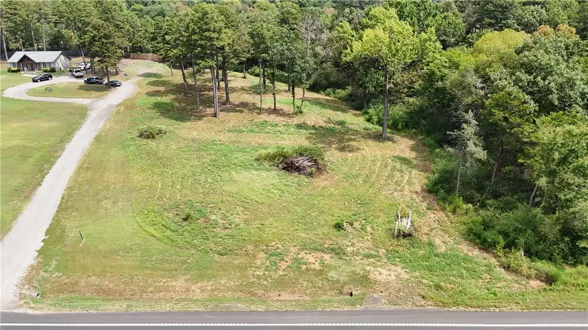 Image 1: Expansive wooded lot offering direct road frontage