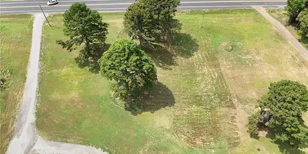 Image 4: Expansive land parcel featuring a gravel driveway,