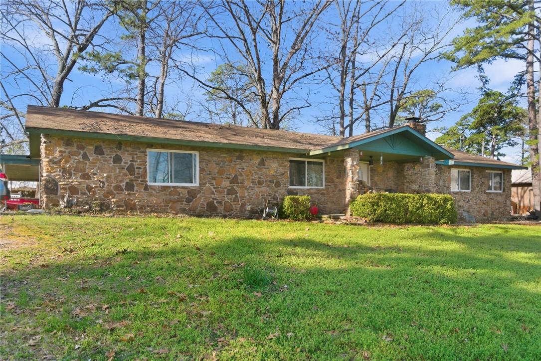 Image 4: Single story home with a front lawn, a chimney, an