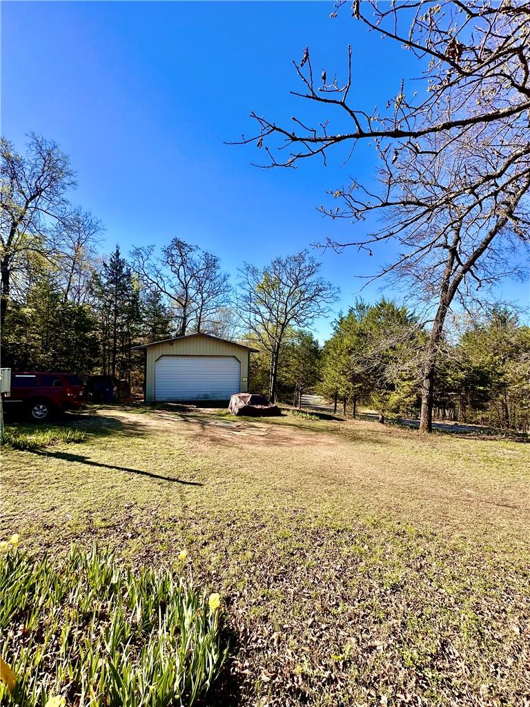 Image 2: View of green lawn with a garage and an outdoor st