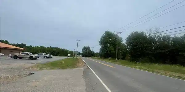 Image 2: Gravel parking area fronting a paved public road,