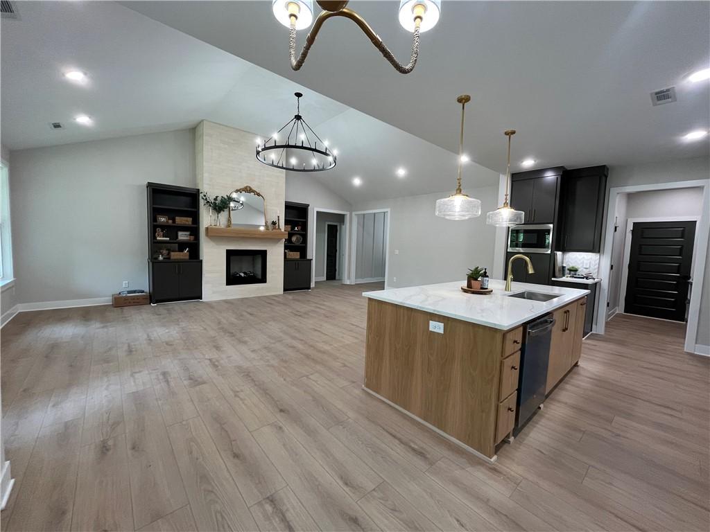 Image 2: Open-concept living area featuring vaulted ceiling