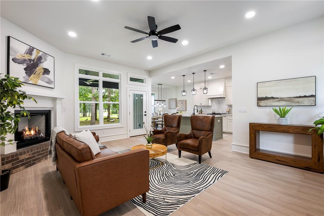 Image 2: Spacious living area featuring a fireplace with a