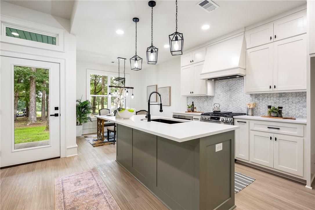 Image 4: Modern kitchen featuring a central island with a q