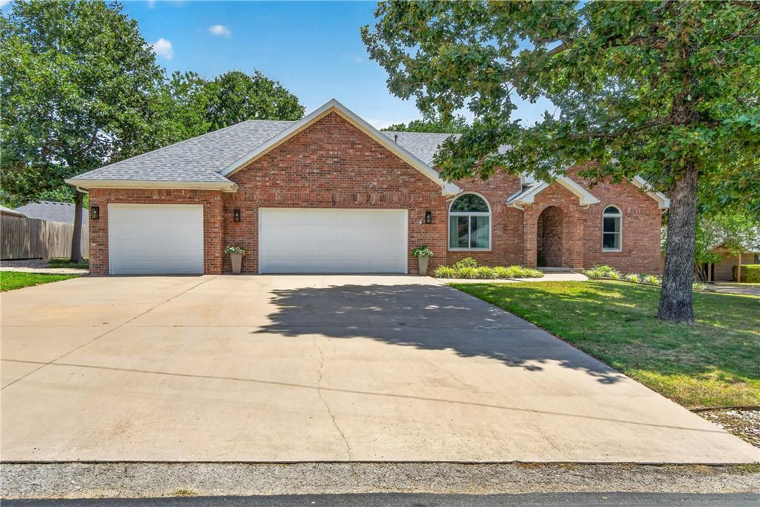 Image 3: Brick exterior with a two-car garage, concrete dri
