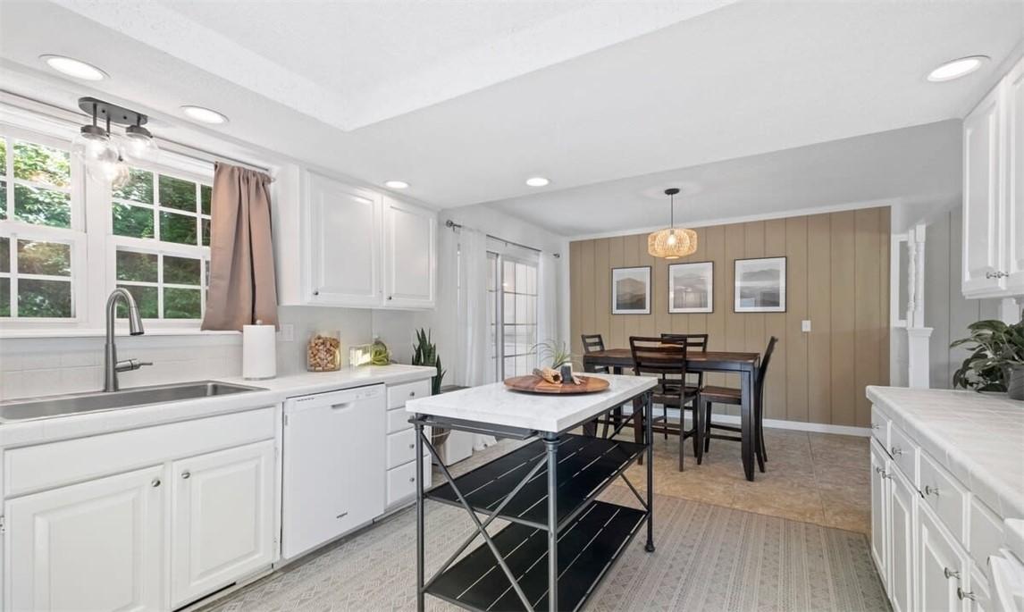 Image 2: Kitchen featuring white cabinetry, light counterto