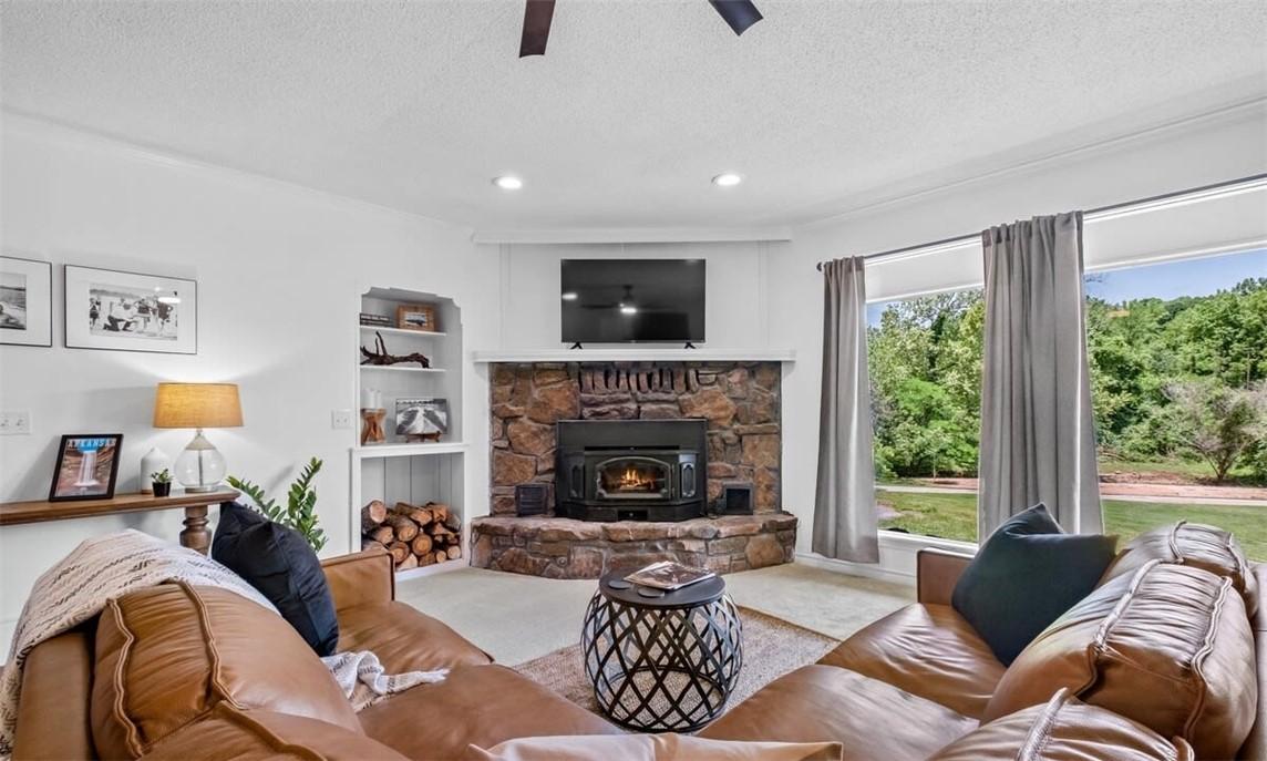 Image 3: Living room with built in shelves, a textured ceil