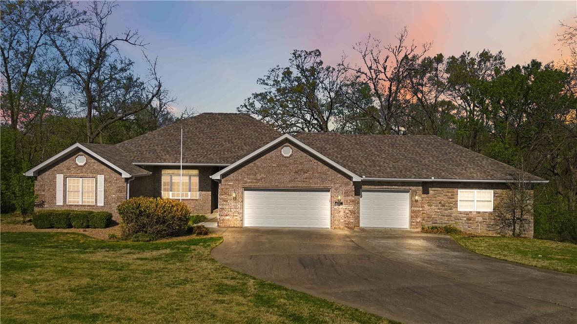 Image 2: Single story home with a garage, driveway, and a f