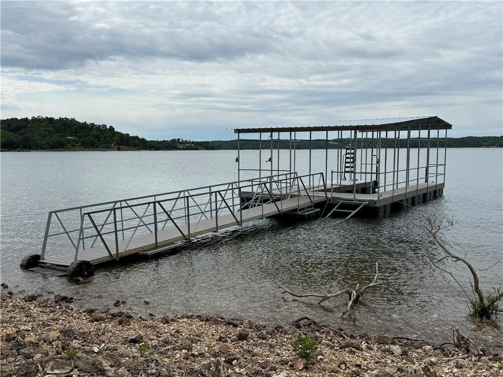 Image 1: Private boat dock featuring a covered structure, m