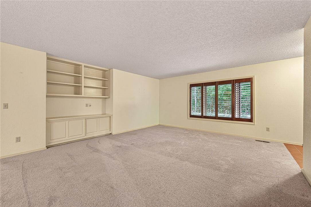 Image 3: Spacious room with light-colored carpeting, built-