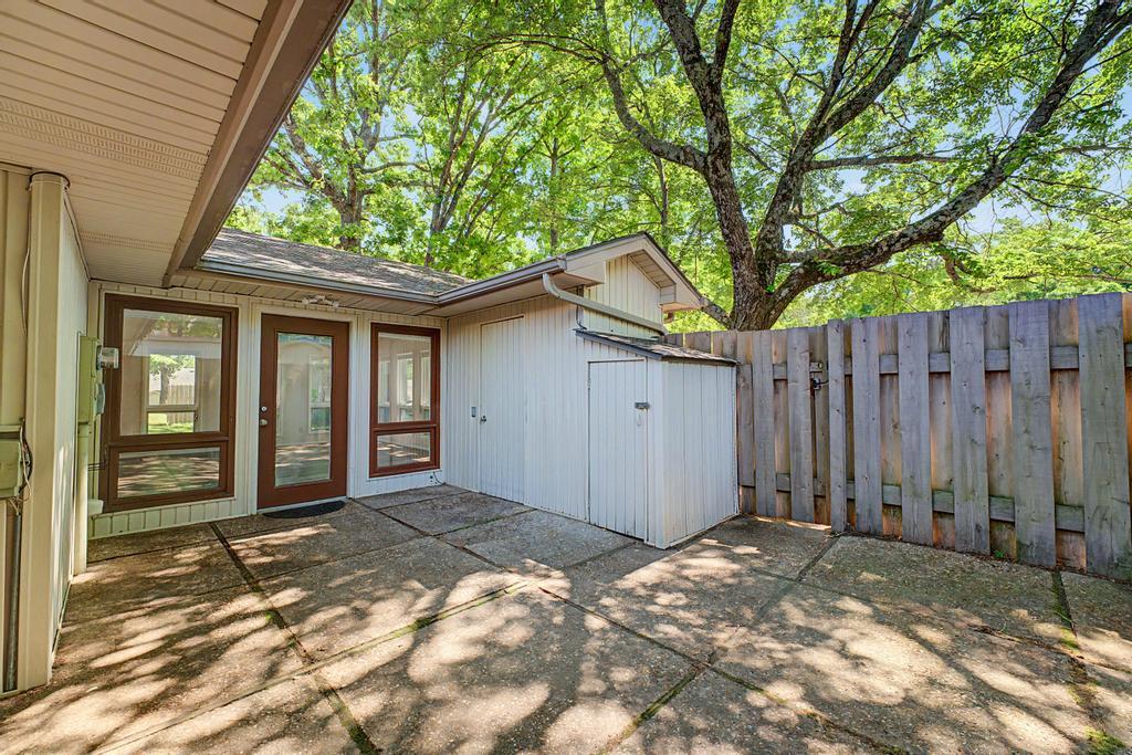 Image 2: Paved patio area featuring a shed, wood privacy fe