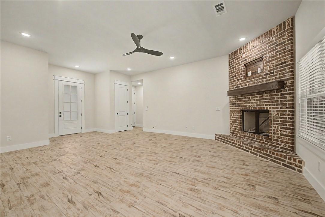 Image 3: Spacious room featuring wood-finish flooring, a br