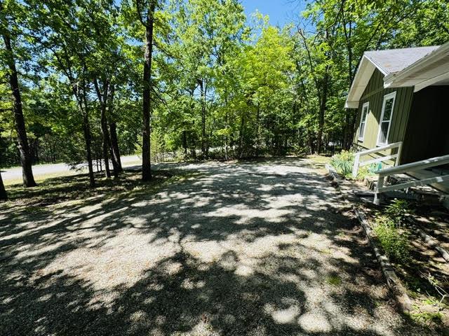 Image 3: Gravel driveway providing ample parking, bordered