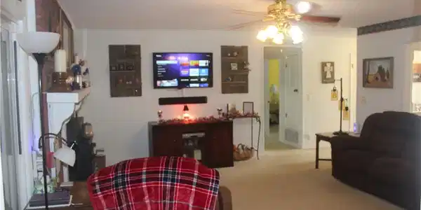 Image 3: Carpeted living area featuring a ceiling fan with