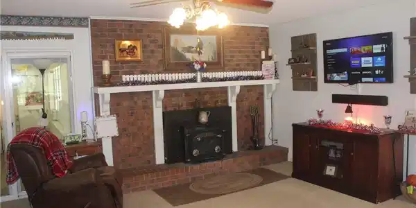 Image 4: Brick fireplace with a wood-burning stove insert,