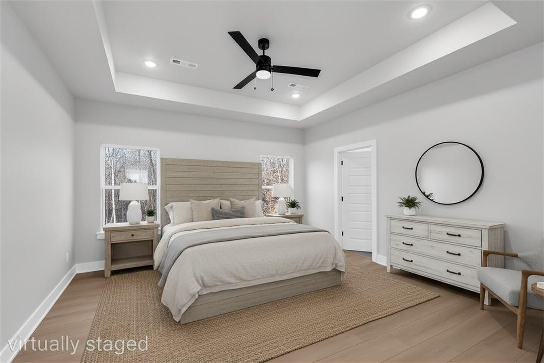 Image 3: Spacious bedroom featuring wood-finish flooring, a