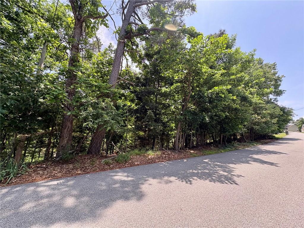 Image 2: Treelined property bordering an asphalt road